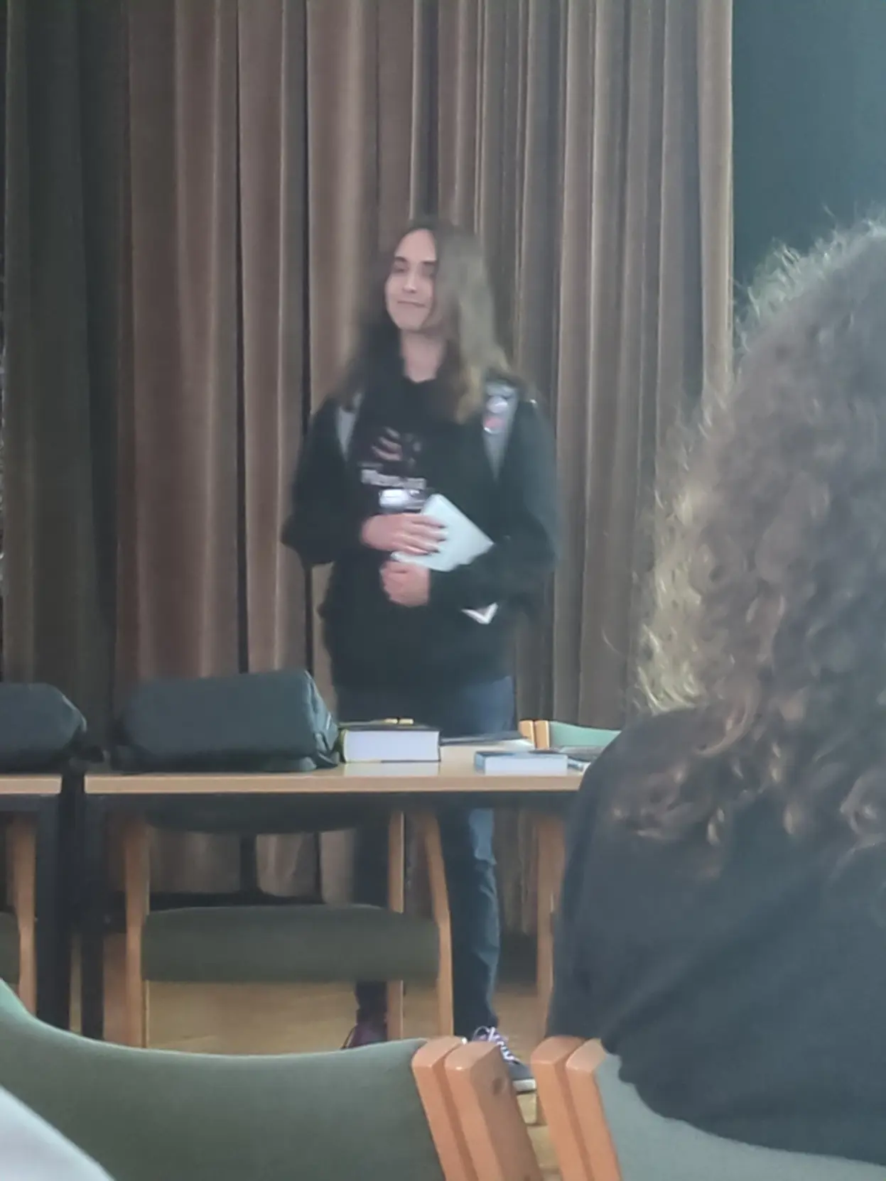 Niskiej jakości zdjęcie Mikołajczyk zrobione z daleka, trzyma jakiś biały obiekt którego nie umiem rozpoznać, jest uśmiechnięta