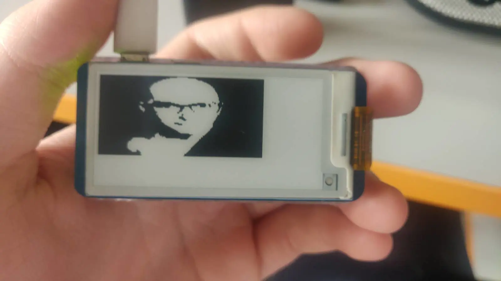 Raspberry Pi Zero 2W z wyświetlaczem e-ink pokazujący niskiej jakości czarno-białe zdjęcie gimpera